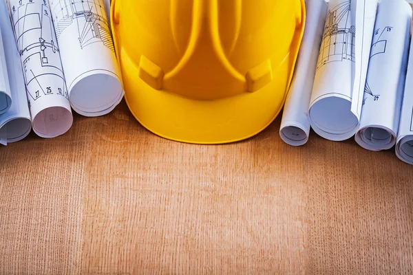 Helmet and heap of construction drawings — Stock Photo, Image