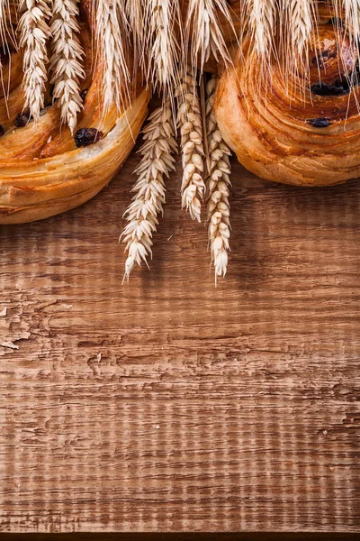 Wheat ears and raisin baked goods — Stock Photo, Image