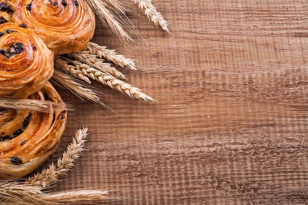 Пшеничные уши со сладкими булочками с изюмом — стоковое фото