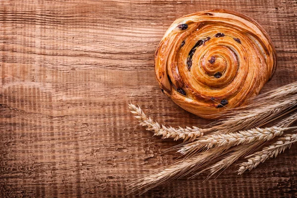 Saboroso rolo de passas e orelhas de trigo — Fotografia de Stock