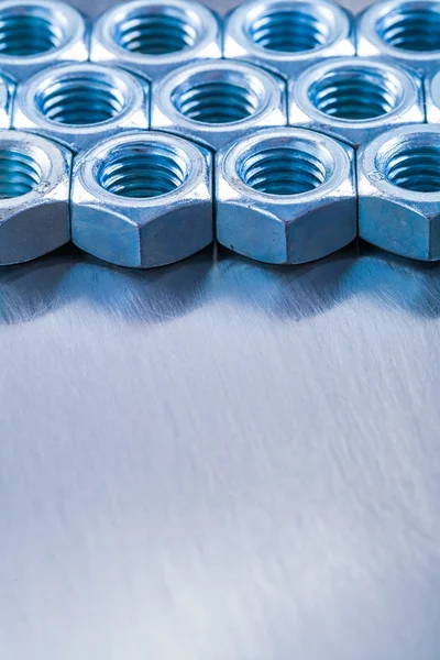 Stainless screw nuts on metallic background — Stock Photo, Image