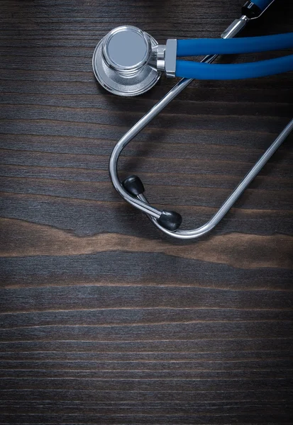 Wooden vintage board with blue medical stethoscope — Stock Photo, Image