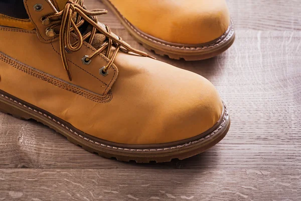 Pair of working boots on wood board — Stockfoto