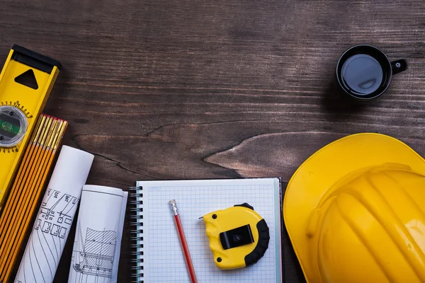 Workbook, pencil, coffee and construction objects