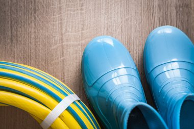 Bükülmüş bahçe hortumu ve su geçirmez gumboots