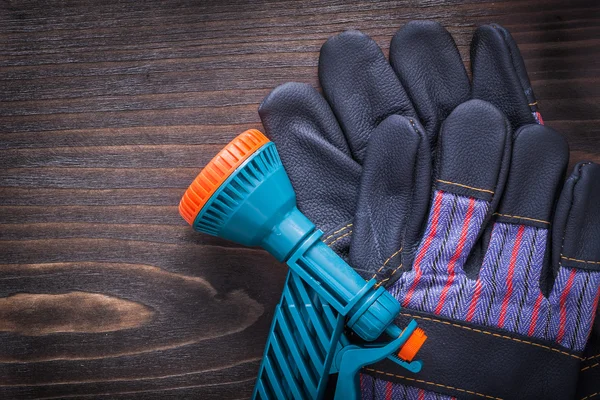 Hose nozzle and rubber safety gloves — Stock Photo, Image