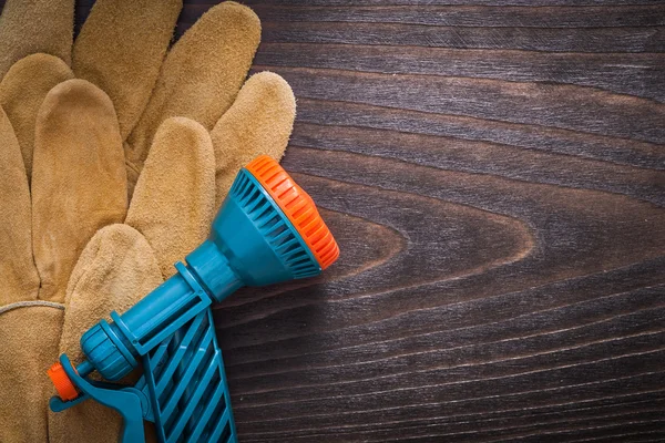 Stříkací tryska a kožené ochranné rukavice — Stock fotografie