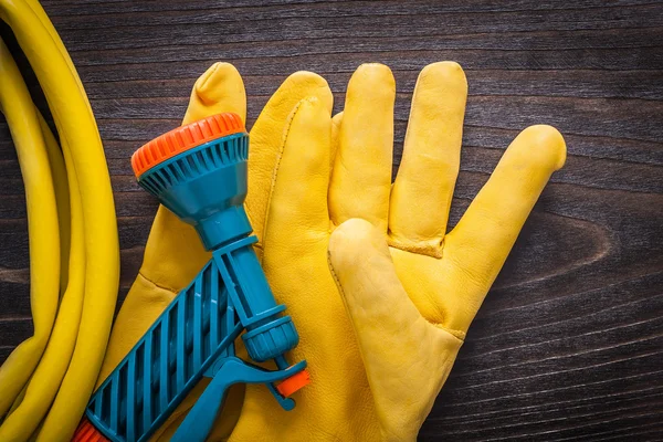 Beschermende handschoenen en hand spuiten slang — Stockfoto