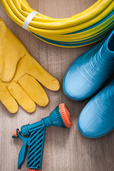 Schlauch mit Sprühdüse, Handschuhe und Gummistiefel — Stockfoto