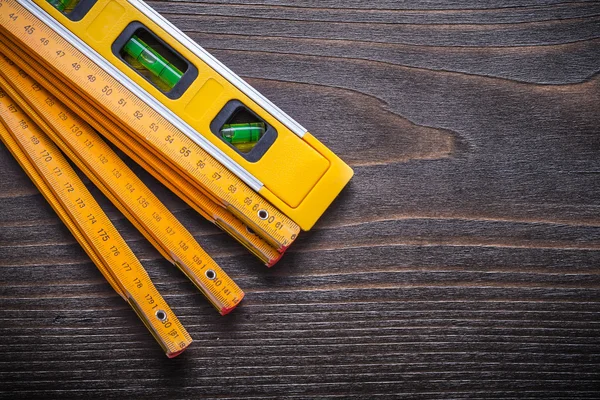 Nível de construção amarelo com medidor de madeira — Fotografia de Stock