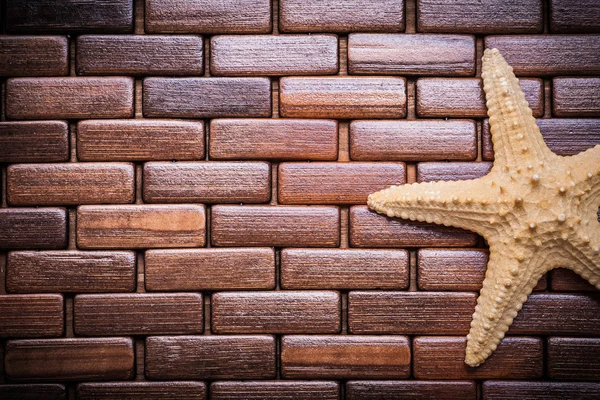 Starfish on checked wooden place mat — Stok fotoğraf