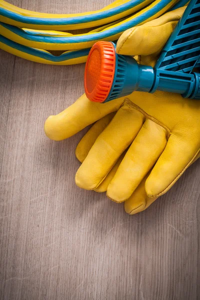 Protective gloves and hand spraying hose — Stock Photo, Image