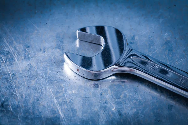 Stainless hook wrench on scratched metallic background close up — Stok fotoğraf