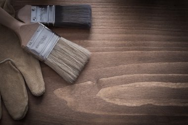 Boya fırçaları ve kahverengi deri koruyucu eldivenler