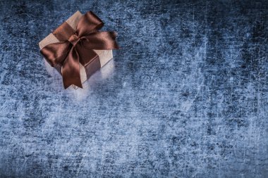 Giftbox Metalik arka plan üzerinde kahverengi yay ile
