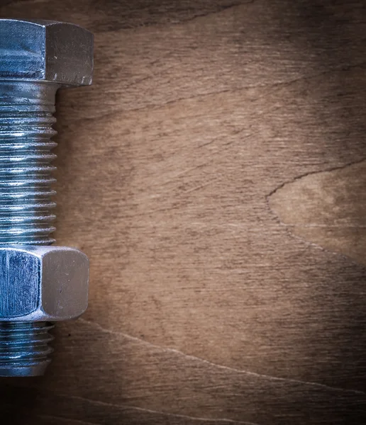 Tornillo con tuerca de construcción sobre tabla de madera — Foto de Stock