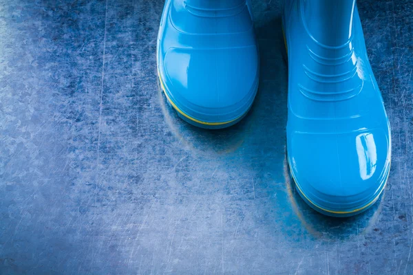Metalik arka plan üzerinde su geçirmez gumboots çifti