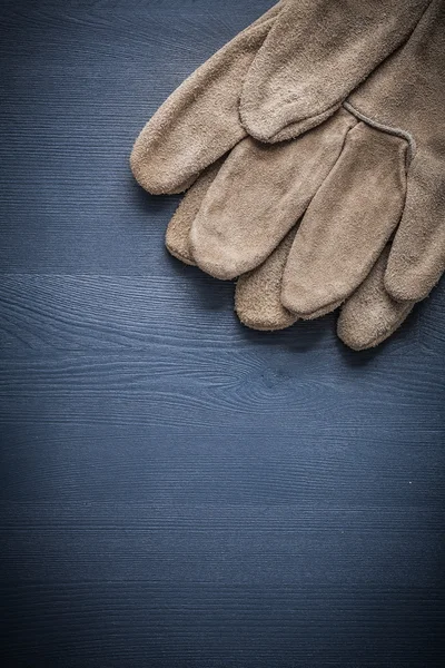 Protective gloves on wood board — Stock Photo, Image