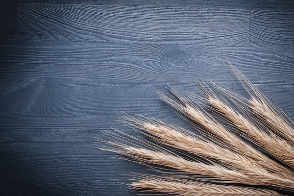 Stack of wheat ears on vintage board — Stock Photo, Image
