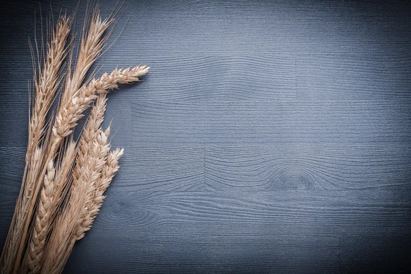 Stack of ears wheat on vintage board — Stock Photo, Image