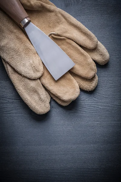 Raspador de pintura de acero en guantes de trabajo — Foto de Stock