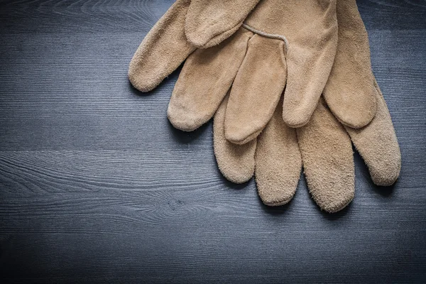 Ochranné rukavice na dřevěné desce — Stock fotografie