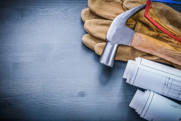 Rollen van blauwdrukken hamer handschoenen bril — Stockfoto