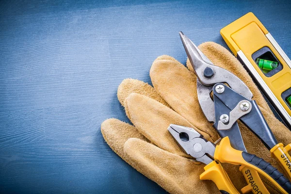 Construction level and safety gloves — Stock Photo, Image