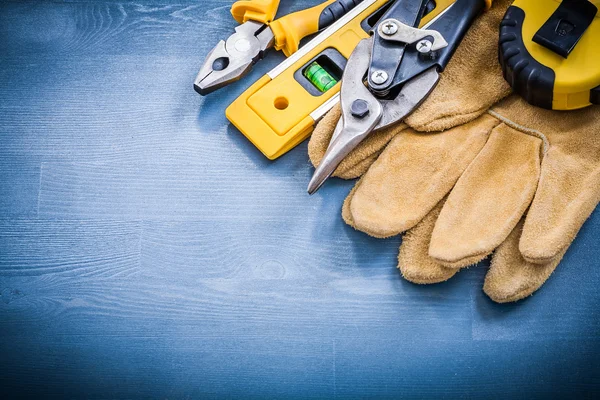 Construction level and protective gloves — Stock Photo, Image