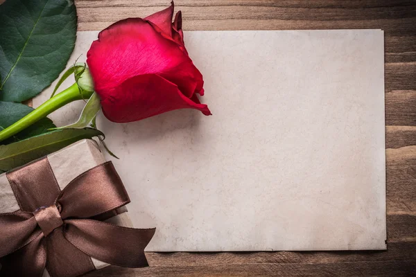 Red rosebud and wrapped gift box — Stock Photo, Image