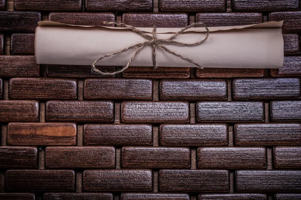 Rolled paper on wicker wooden mat — Stock Photo, Image