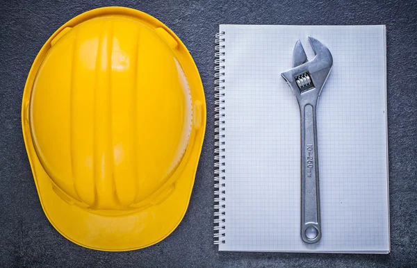 Notebook, building helmet, adjustable wrench — Stock Photo, Image