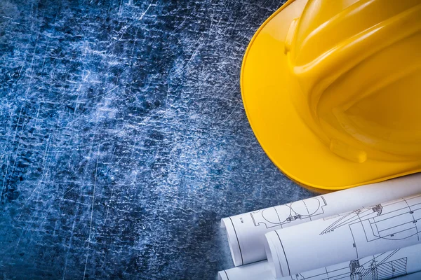 Blueprint rolls and yellow hard hat — Stock Photo, Image