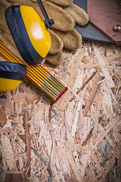 Beschermende handschoenen, meter, handzaag, oorkappen — Stockfoto