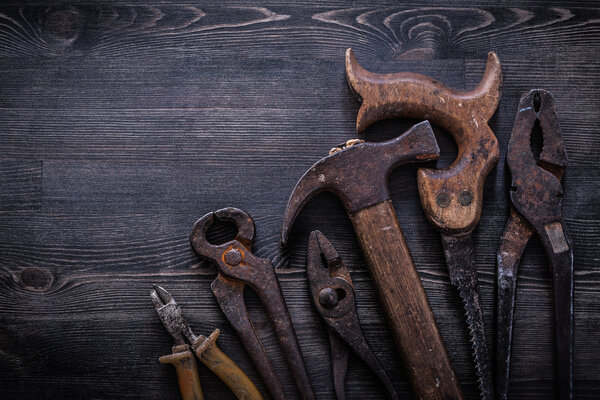 Vintage rusted handsaw, pliers, hammer