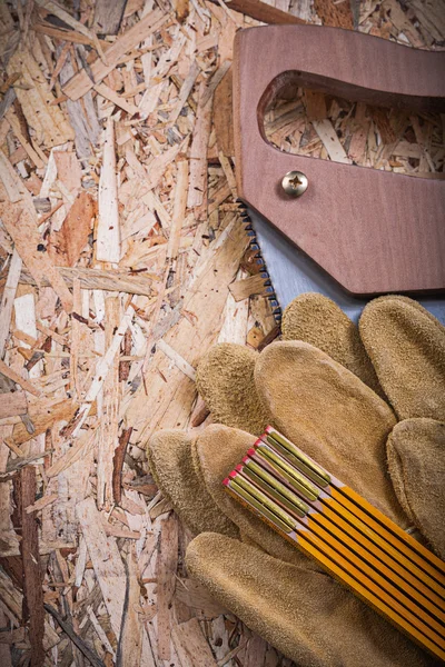 Lederen handschoenen, houten meter en handzaag — Stockfoto