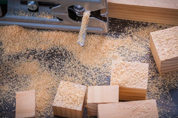 Electrical fretsaw sawdust and wooden bricks — Stock Photo, Image