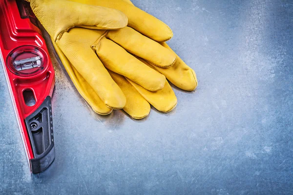Construction level and protective gloves — Stock Photo, Image