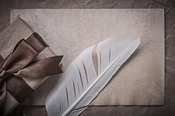 Giftbox, sheet of wrapping paper and quill — Stock Photo, Image