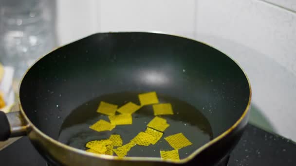 Brambůrky se připravují na pánvi v rozpáleném oleji. Nezdravé jídlo. — Stock video