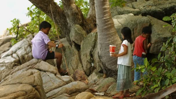 PHUKET. TAILANDIA - CIRCA OCT 2014: Niños locales caminando y jugando en la playa del océano — Vídeos de Stock