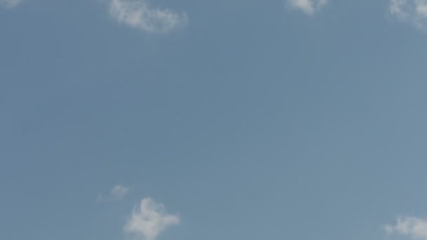 Cielo con unas pocas nubes y un avión volando alto con traza — Vídeo de stock