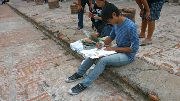 AYUTTHAYA. TAILANDIA - CIRCA FEB 2015: Artistas locales se sientan en un paso y pintan en Wat Yai Chai Mongkhon en Tailandia . — Vídeo de stock