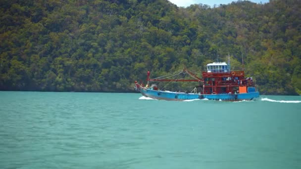 Fiskebåt som passerar en skogklädda Tropical Island i Timelapse — Stockvideo