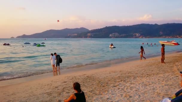 Patong. phuket. Thailand - ca. Januar 2015: Strandbesucher genießen den Sand und das Meer am Patong-Strand, während die Sonne über dem Horizont untergeht. — Stockvideo