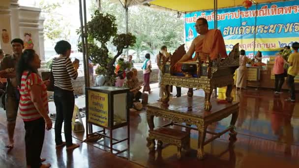 Sim, sim. THAILAND - CIRCA FEB 2015: Os adoradores budistas oferecem oferendas a um monge sênior que oferece bênçãos e exortações em Wat Phanan Choeng, em Ayutthaya. Tailândia . — Vídeo de Stock