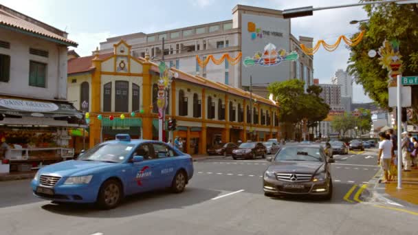 Tipico traffico pedonale e veicolare su una strada centrale della città attraverso il distretto indiano di Singapore Video Stock