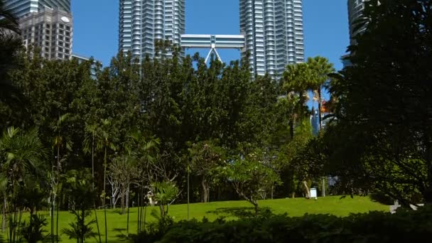 Yukarı doğru atış ünlü Petronas ikiz Kuleler'in devirme. kadar açık mavi gökyüzüne ulaşmaktadır. Malezya'nın başkenti Kuala Lumpur Şehir Merkezi Park görüldüğü gibi. — Stok video