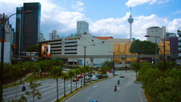 Tipico traffico urbano nel centro di Kuala Lumpur. Malesia. con la famosa torre di Kuala Lumpur e un treno pendolare sullo sfondo . — Video Stock