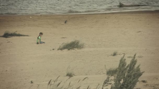 Video 1080p - Niño triste sentado en una orilla del río — Vídeos de Stock